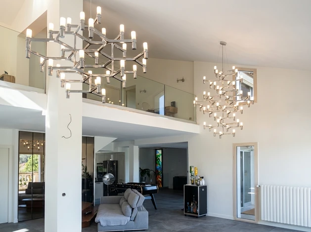 Une porte d'entrée et porche couvert détail sur une maison avec parement gris, garniture blanche, brique rouge, une porte d'entrée en bois